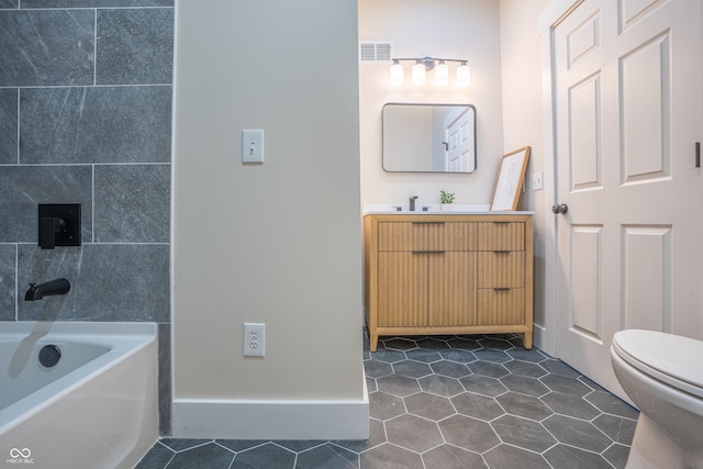 full bathroom featuring vanity, toilet,  shower combination, and tile patterned flooring