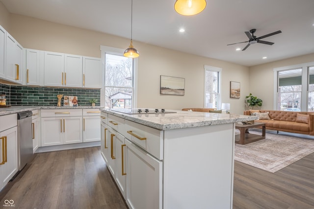 kitchen featuring pendant lighting, dishwasher, light stone counters, and white cabinets