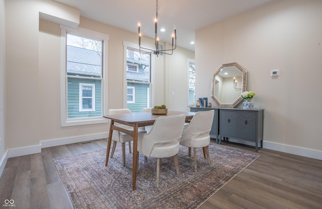 dining area featuring dark wood-type flooring and a chandelier