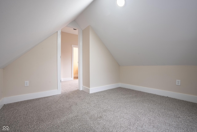 additional living space with lofted ceiling and carpet flooring