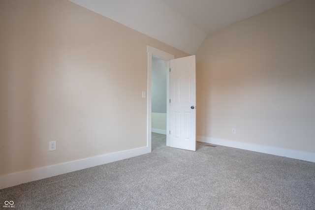 carpeted spare room with lofted ceiling