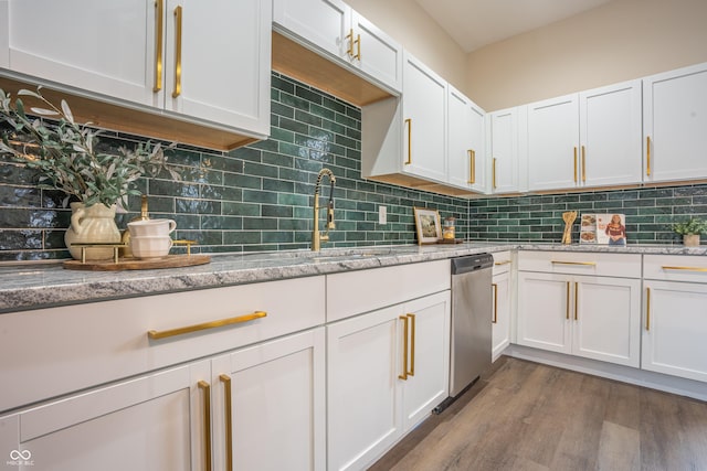 kitchen featuring wood-type flooring, white cabinets, light stone counters, and decorative backsplash