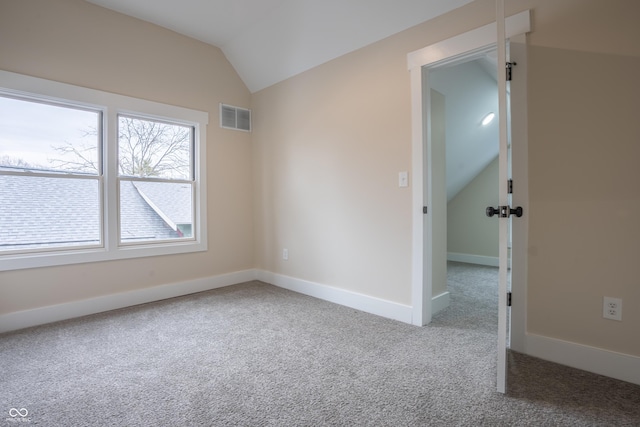 empty room with lofted ceiling and carpet