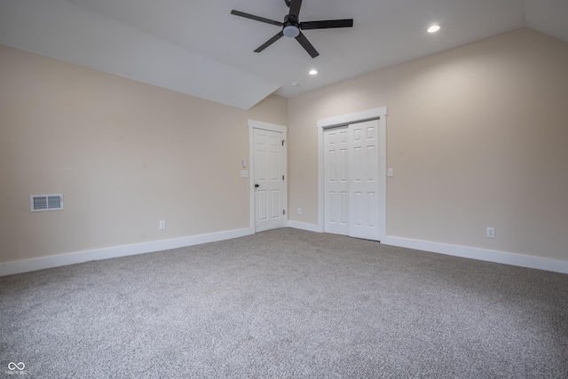 carpeted spare room featuring lofted ceiling and ceiling fan