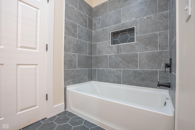 bathroom featuring tile patterned flooring and tiled shower / bath