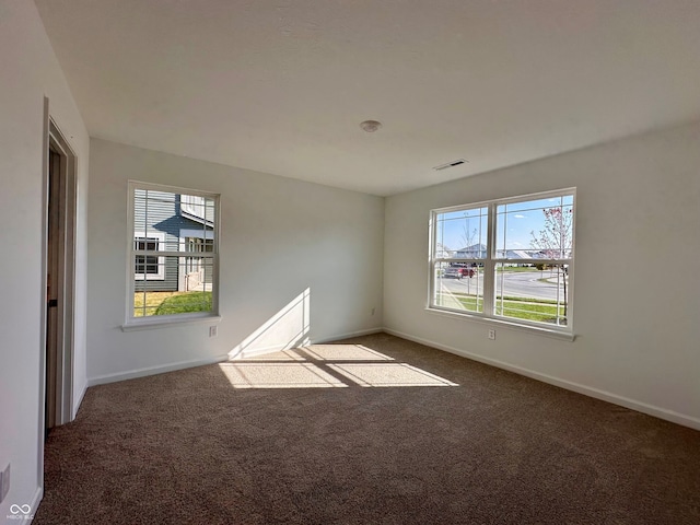 unfurnished room with dark carpet