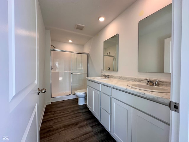 bathroom with walk in shower, vanity, toilet, and hardwood / wood-style floors