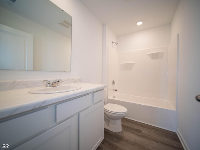 bathroom featuring visible vents, toilet, vanity, wood finished floors, and shower / bathtub combination