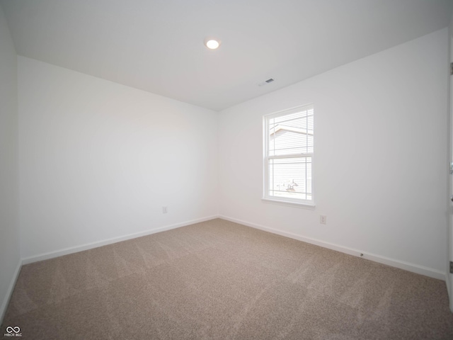 carpeted spare room featuring recessed lighting, visible vents, and baseboards