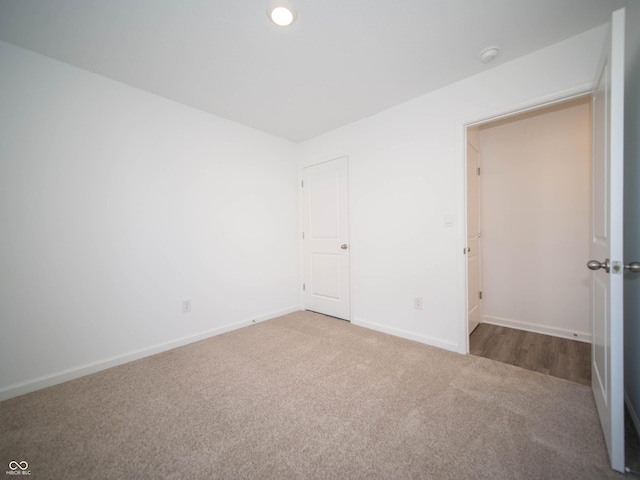 carpeted spare room featuring recessed lighting and baseboards