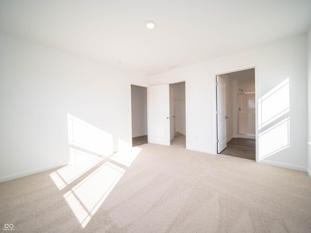 unfurnished bedroom with light carpet, a closet, and baseboards