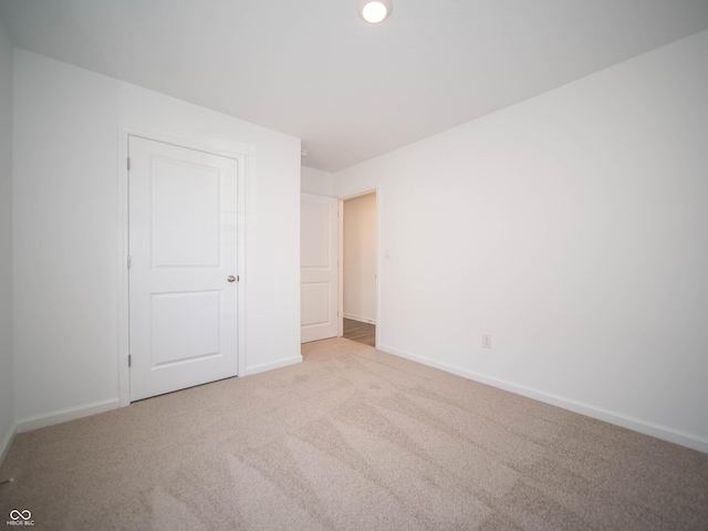 unfurnished bedroom with carpet floors and baseboards