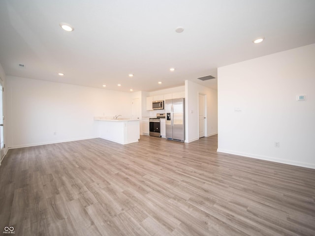 unfurnished living room featuring light wood-style floors, recessed lighting, visible vents, and baseboards