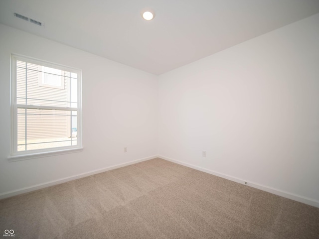 unfurnished room with carpet, visible vents, baseboards, and recessed lighting