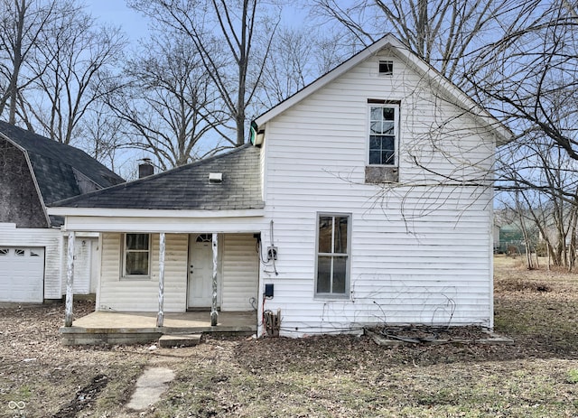 rear view of house featuring covered porch and a garage