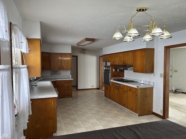 kitchen with under cabinet range hood, light countertops, oven, light floors, and a sink