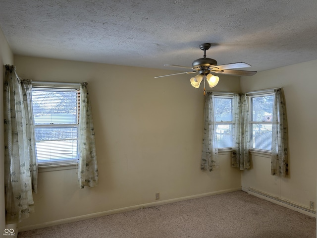 unfurnished room with carpet flooring, a baseboard heating unit, a textured ceiling, and baseboards