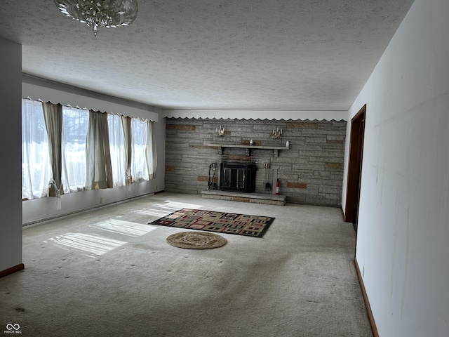 unfurnished living room with a textured ceiling, a fireplace, and light colored carpet