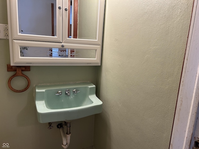 bathroom featuring a sink and a textured wall