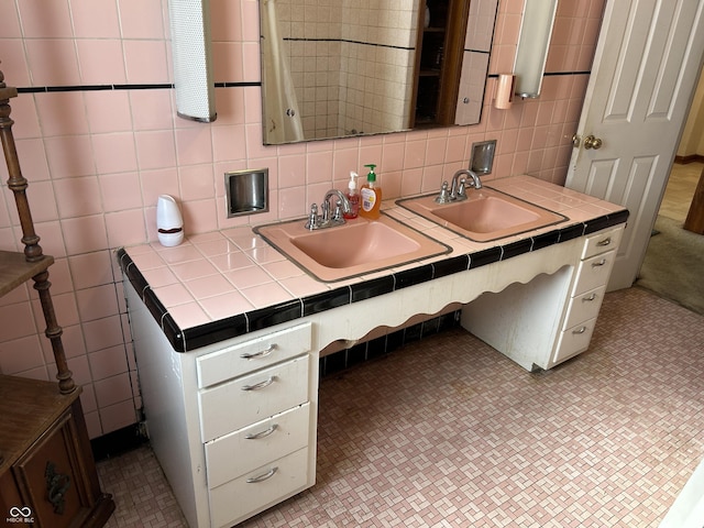 bathroom featuring tile walls and a sink