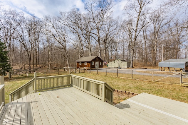 wooden deck with an outdoor structure, a lawn, and fence