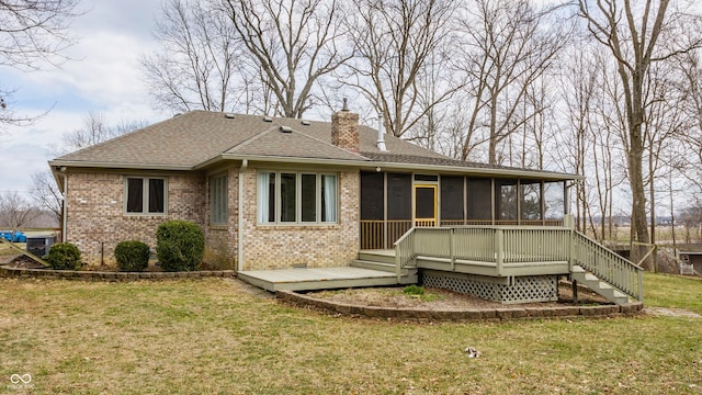 back of property featuring a lawn, a sunroom, a shingled roof, brick siding, and a chimney