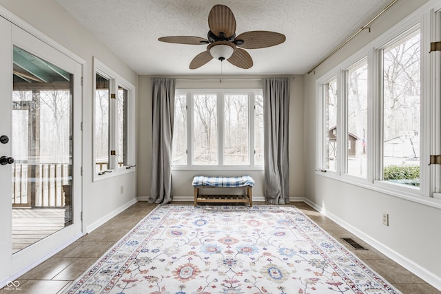 sunroom / solarium with visible vents, plenty of natural light, and a ceiling fan