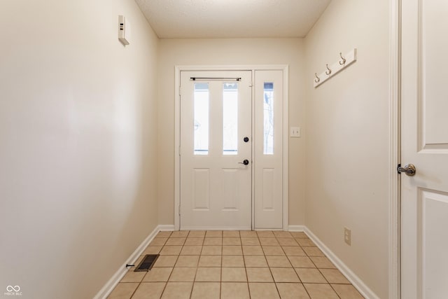 entrance foyer with light tile patterned floors, visible vents, a textured ceiling, and baseboards