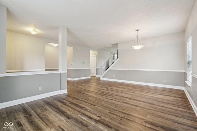 spare room featuring dark hardwood / wood-style floors and a textured ceiling