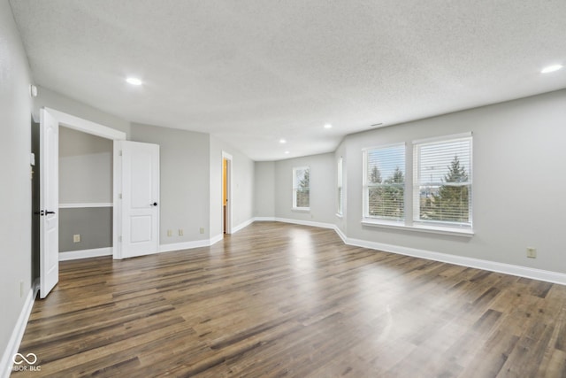 empty room featuring dark hardwood / wood-style floors and a textured ceiling