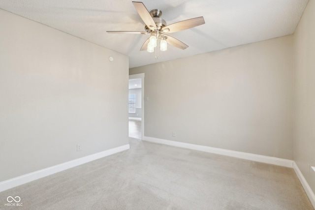 spare room featuring light carpet and ceiling fan