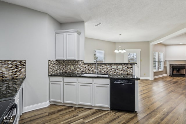 kitchen featuring dishwasher, sink, white cabinets, dark hardwood / wood-style flooring, and hanging light fixtures