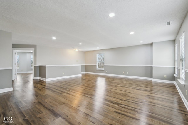 unfurnished room with dark hardwood / wood-style floors and a textured ceiling