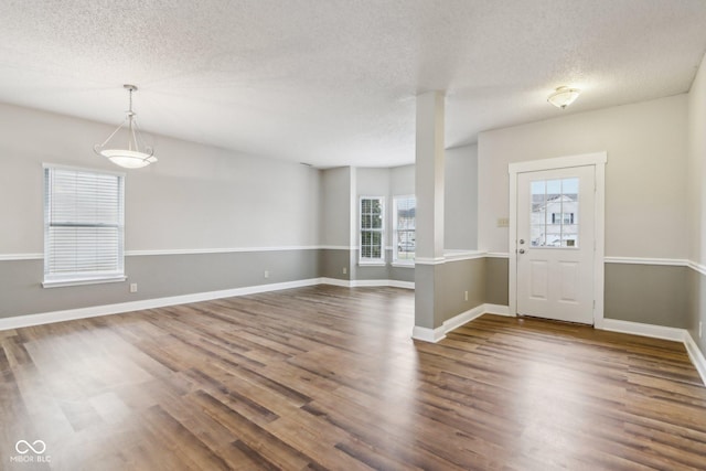 foyer with dark wood-type flooring and a textured ceiling