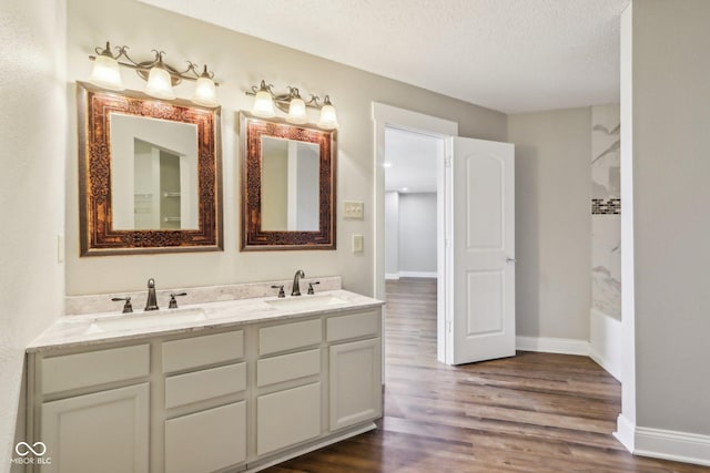 bathroom with vanity, hardwood / wood-style floors, and a textured ceiling