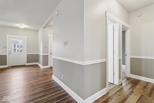 entrance foyer with a textured ceiling and dark hardwood / wood-style flooring