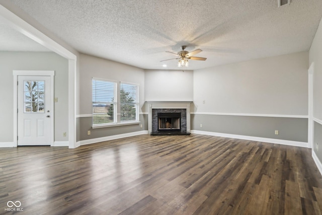 unfurnished living room with ceiling fan, dark hardwood / wood-style flooring, and a textured ceiling