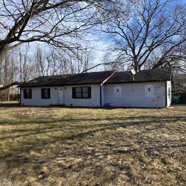 rear view of house featuring a yard