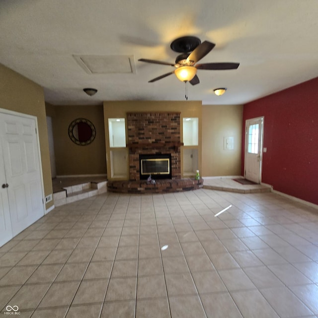 unfurnished living room featuring ceiling fan, light tile patterned floors, and a fireplace