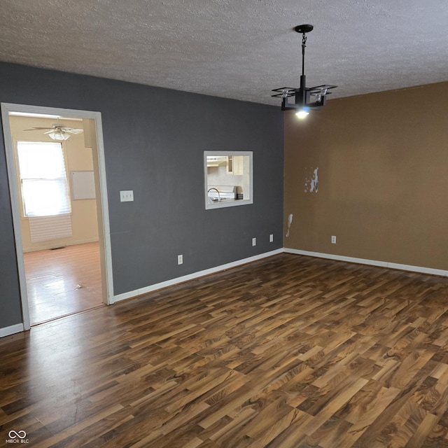 spare room featuring dark hardwood / wood-style floors, sink, and a textured ceiling