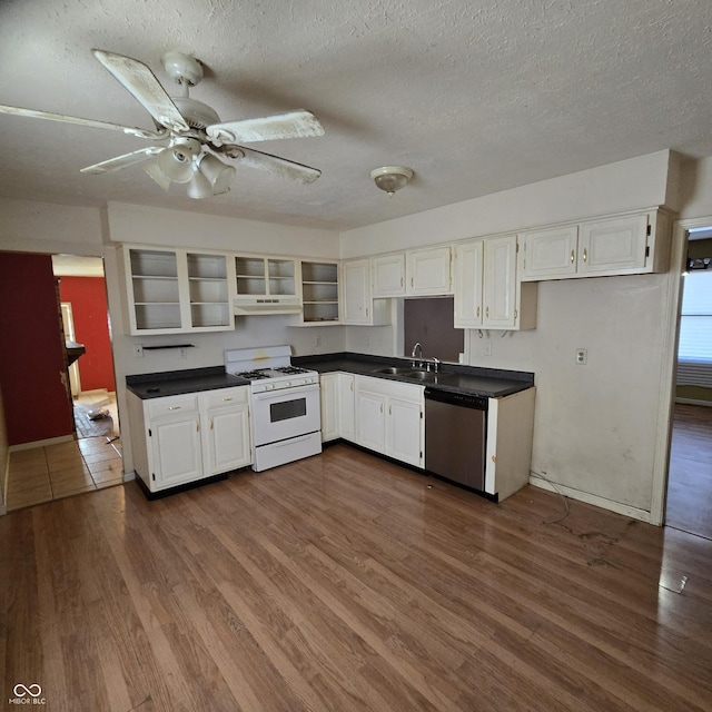 kitchen with white cabinetry, dark hardwood / wood-style floors, white gas range, and dishwasher