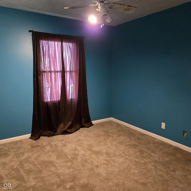 carpeted spare room with ceiling fan and a textured ceiling