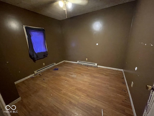 spare room with a baseboard heating unit, hardwood / wood-style floors, and ceiling fan