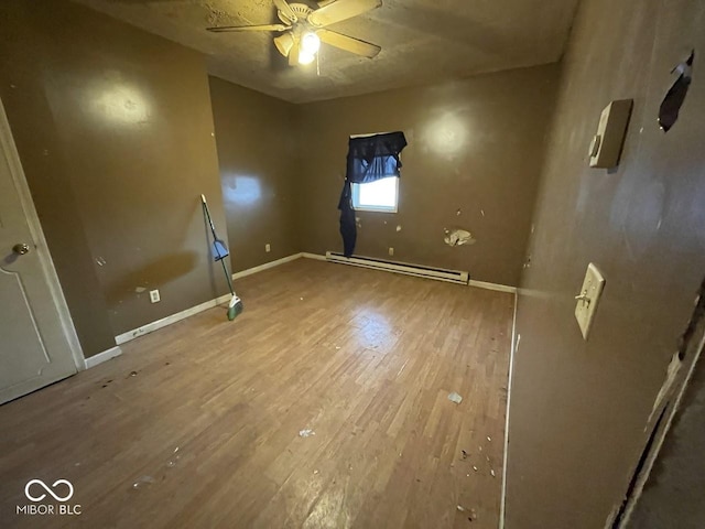 empty room with baseboard heating, ceiling fan, and wood-type flooring