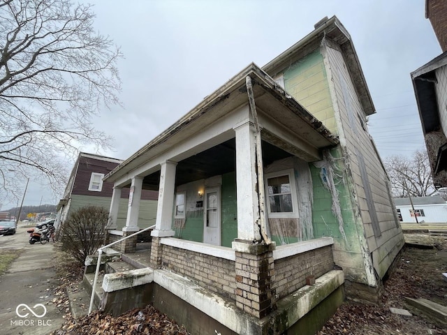 view of side of home featuring covered porch