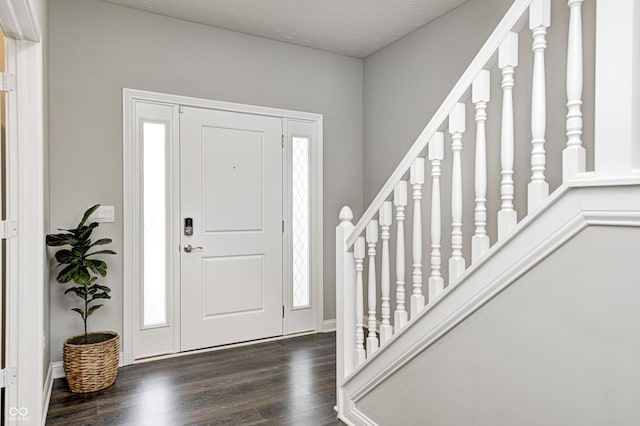 entryway featuring dark hardwood / wood-style flooring and a textured ceiling