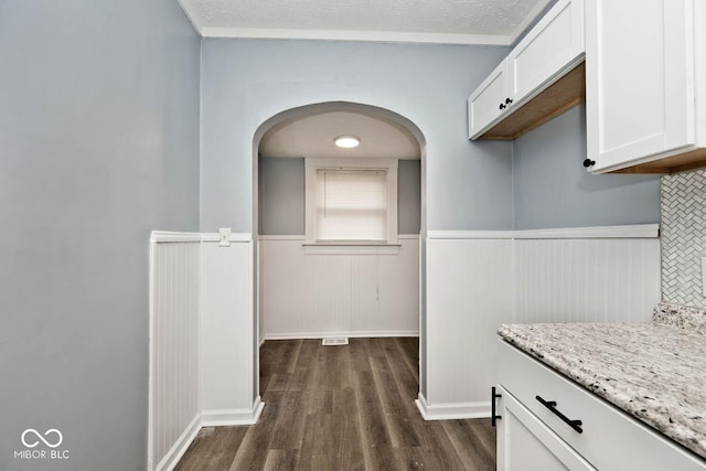 corridor with dark wood-type flooring and a textured ceiling