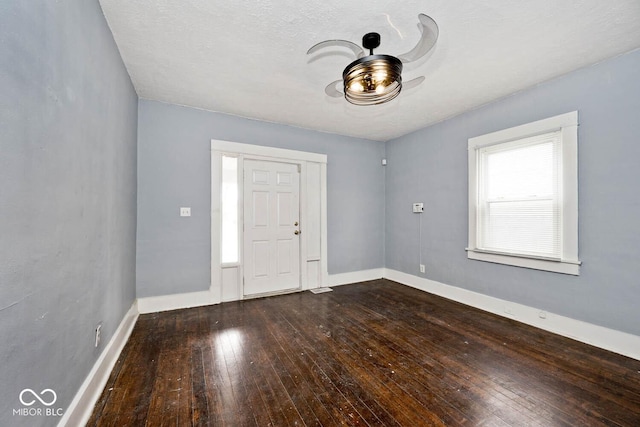 entryway featuring ceiling fan, dark hardwood / wood-style floors, and a textured ceiling