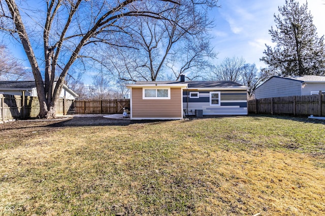 rear view of property with a lawn and central air condition unit