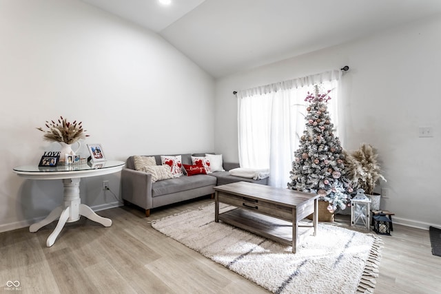 living room featuring vaulted ceiling and light hardwood / wood-style flooring